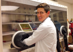 Osborn working at a glove box in the NSSPI nuclear forensics laboratory.